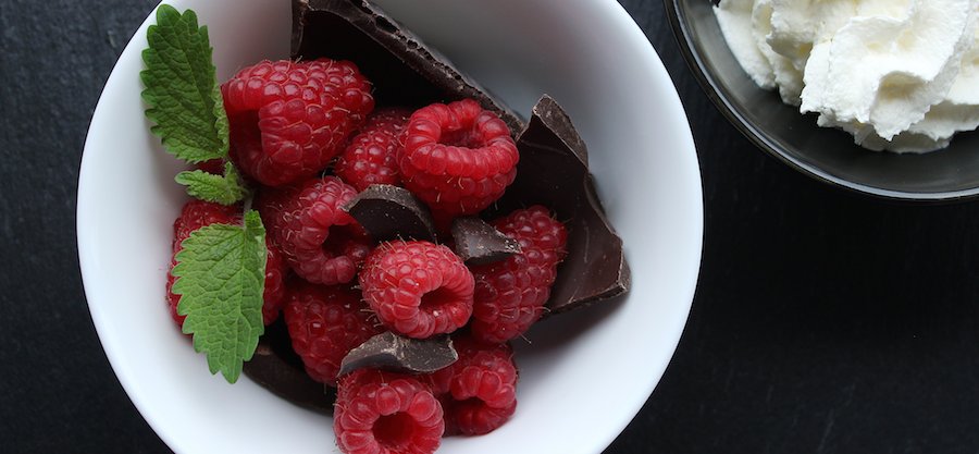 top-view-of-raspberries-chocolate-and-mint-in-white-dish